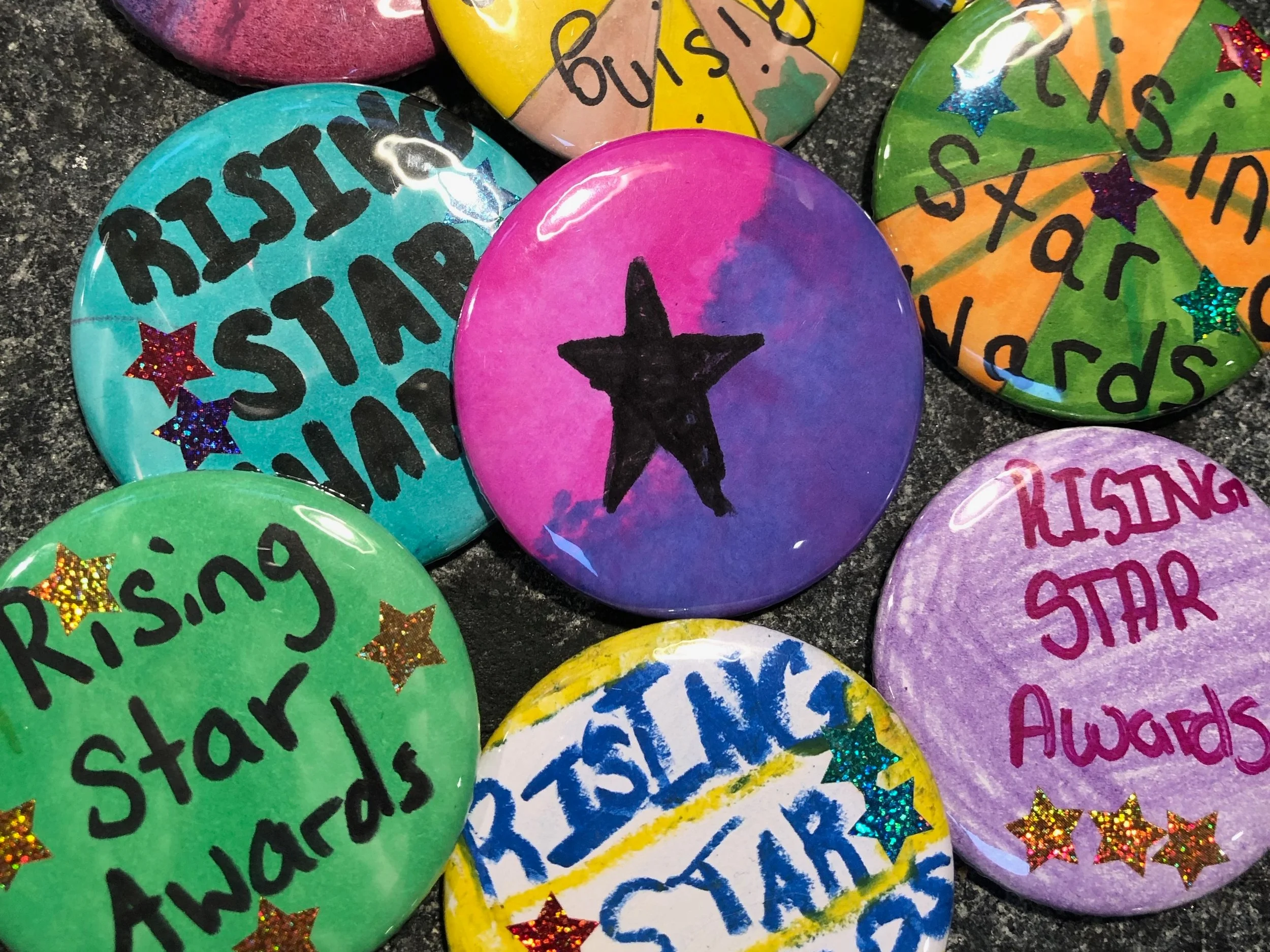 Each student made a button. Copies were made so that each 5th grader could be handed their own button at graduation . “Every kid is a rising star.” The children didn’t want anyone to feel left out since only 3 students would win.