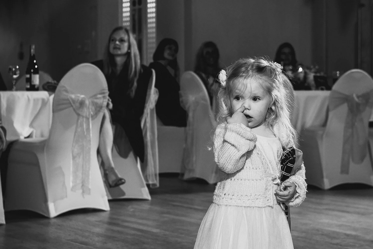 funny picture of little girl picking nose at wedding