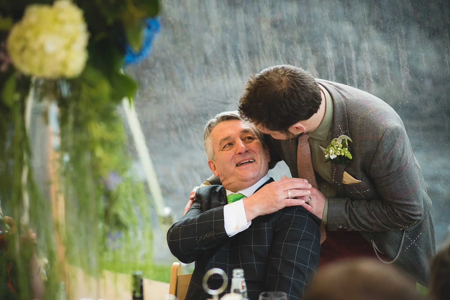 son hugs father at castle wedding in clevedon