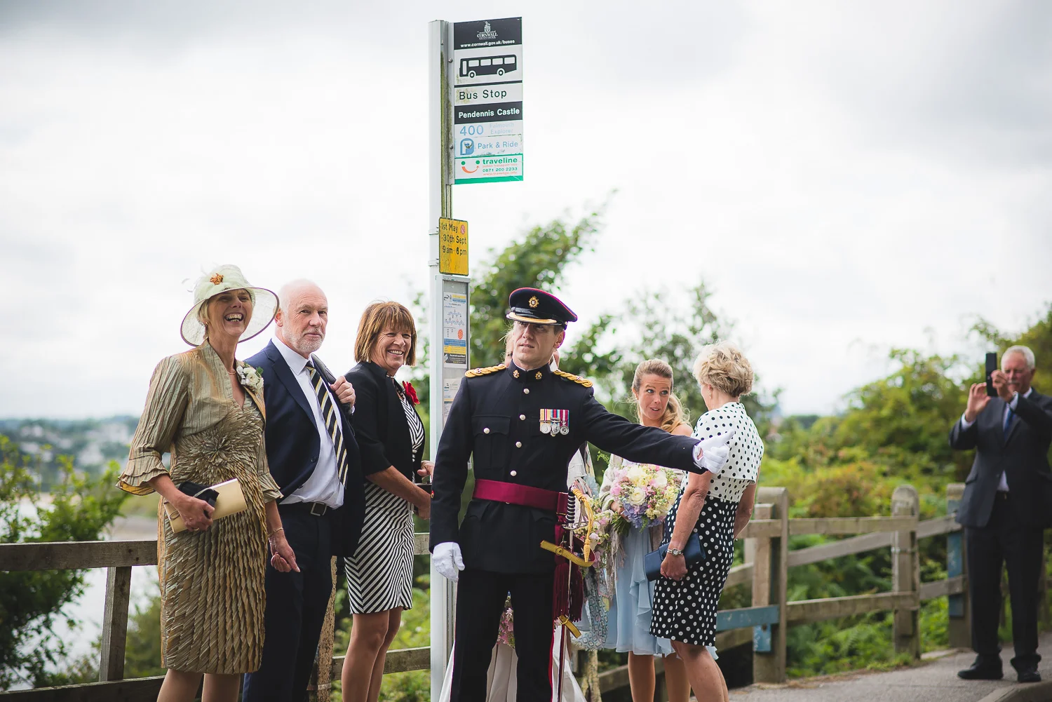 funny wedding picture of army groom waiting for bus by seaside