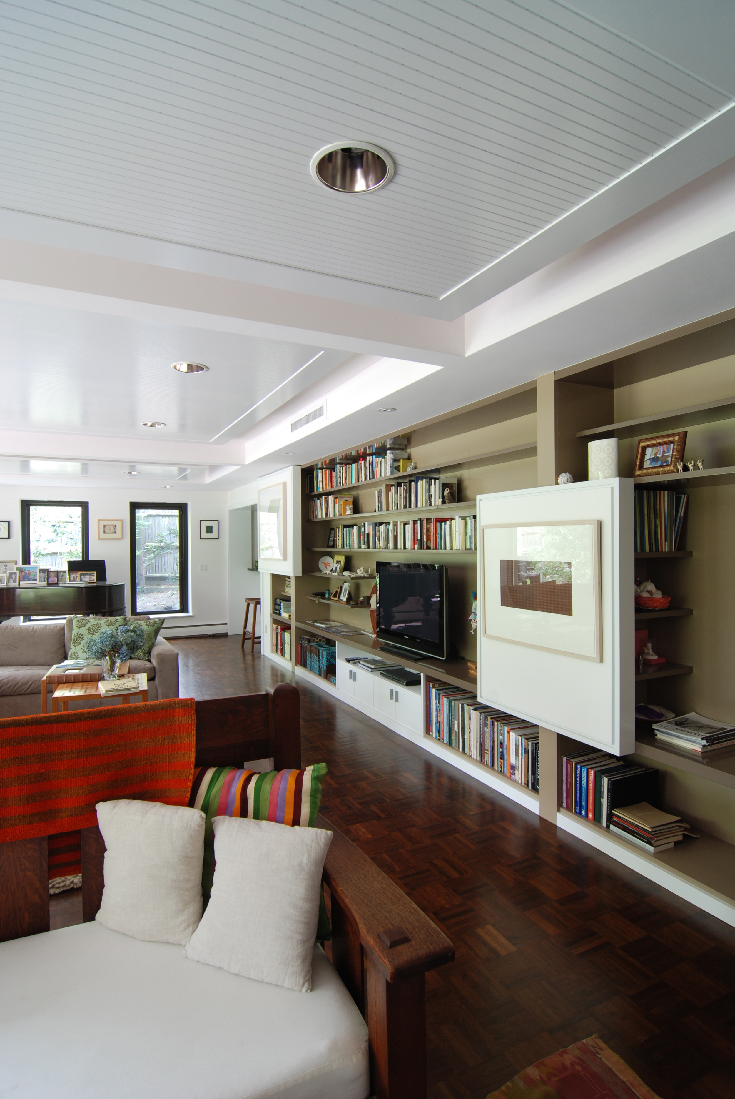  The family room was re-imagined with a custom wall of shelving and new ceiling panels. 
