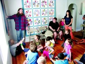   Eliot Reed, left, describes textiles to kids at Park Place Arts. The textile exhibit runs through Aug. 31.  