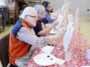   Jim Knotts paints the sky around a moon in his winter landscape during a class by Park Place Arts at Mounds State Park on Saturday. The class was so popular that a second was added.  