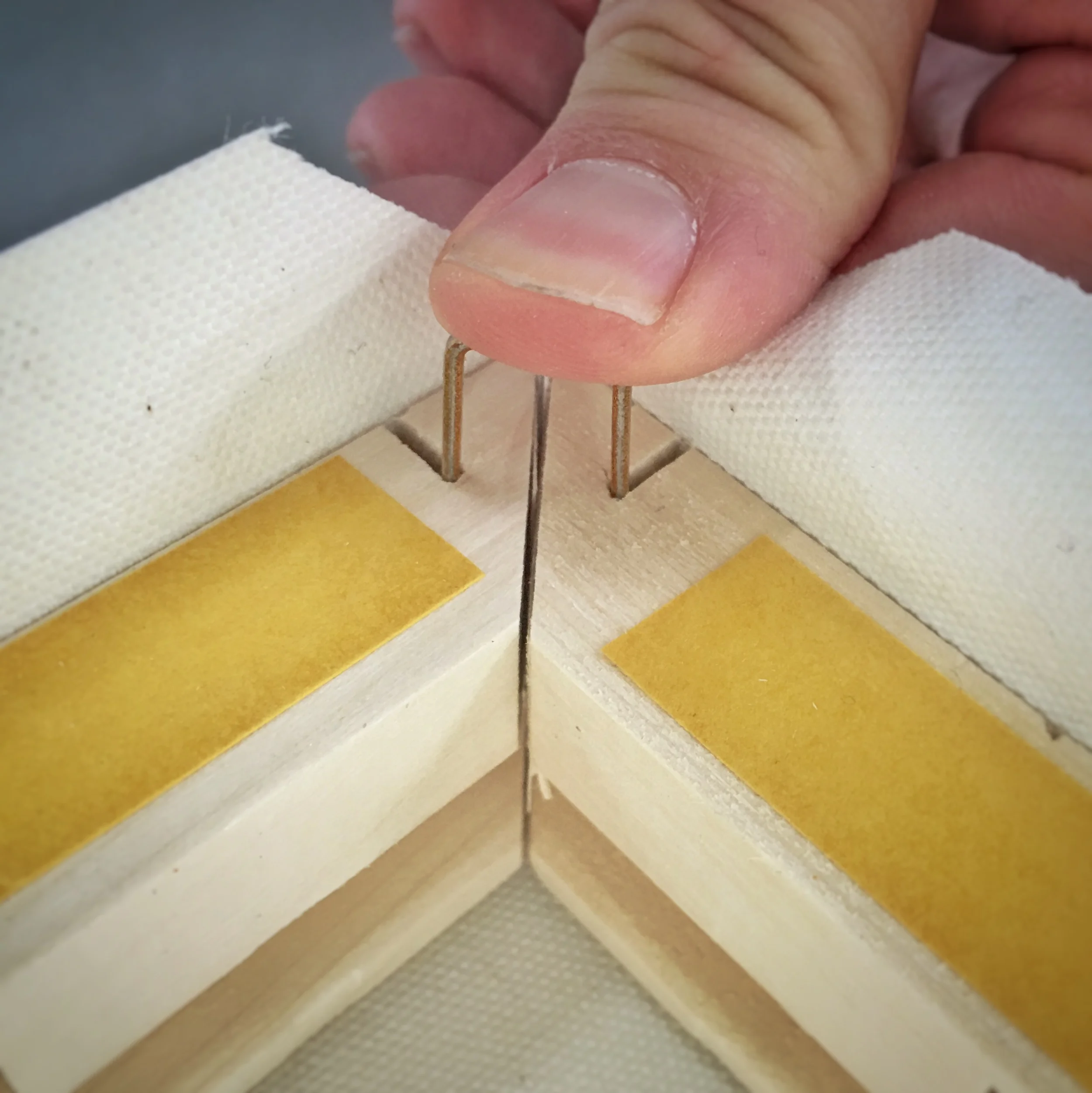 U shaped fasteners allow the canvas to fold into the miter of the stretcher frame creating neat and perfectly folded corners. 