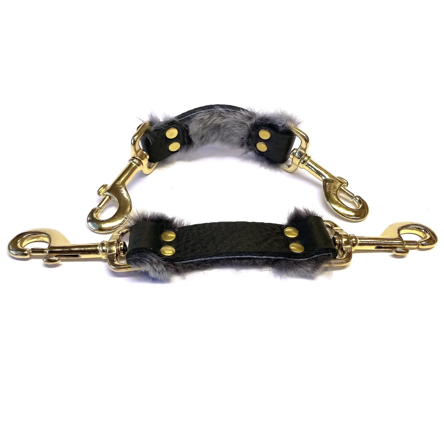 pair of black leather bdsm straps lined in gray sheepskin fur with solid brass snaps