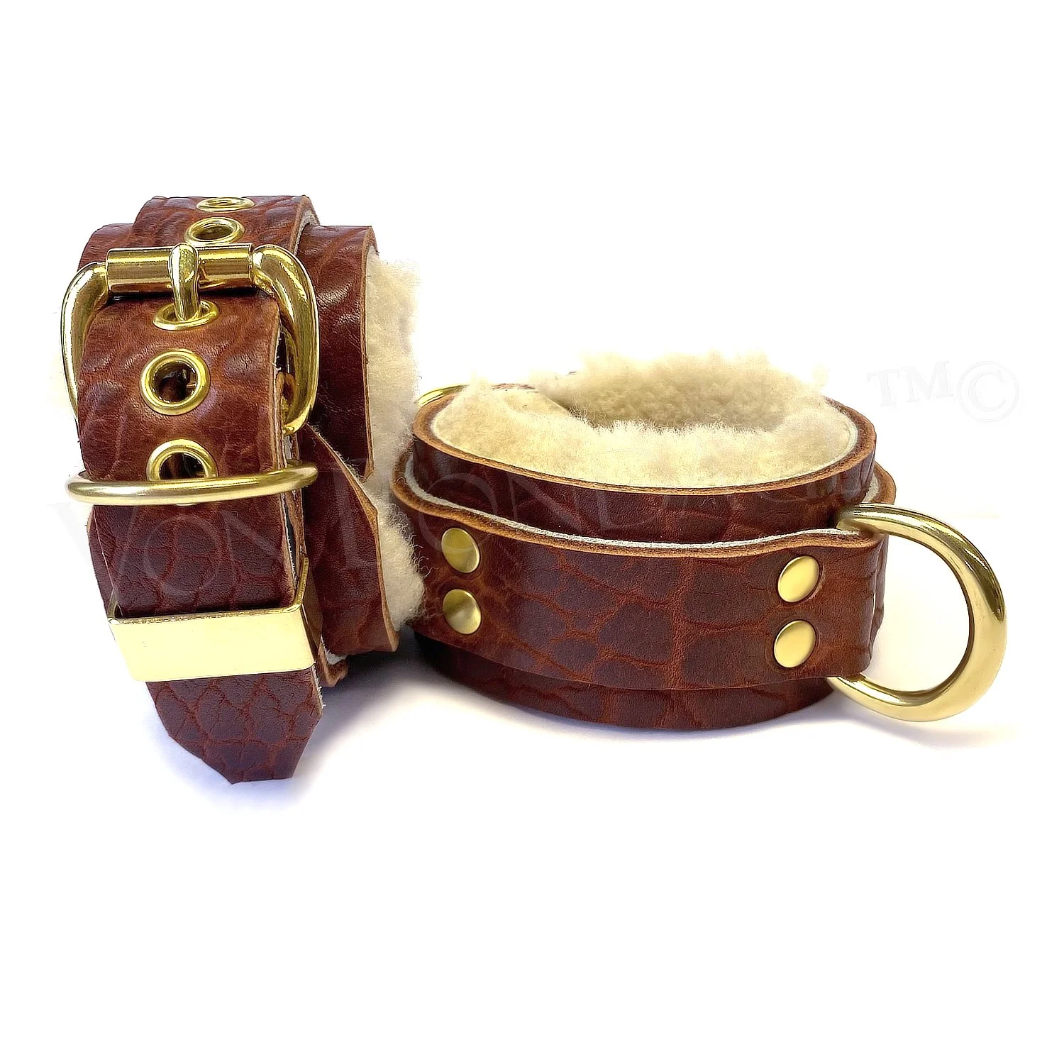 Fur-lined in restraints in brass, cream sheepskin, brown bison leather