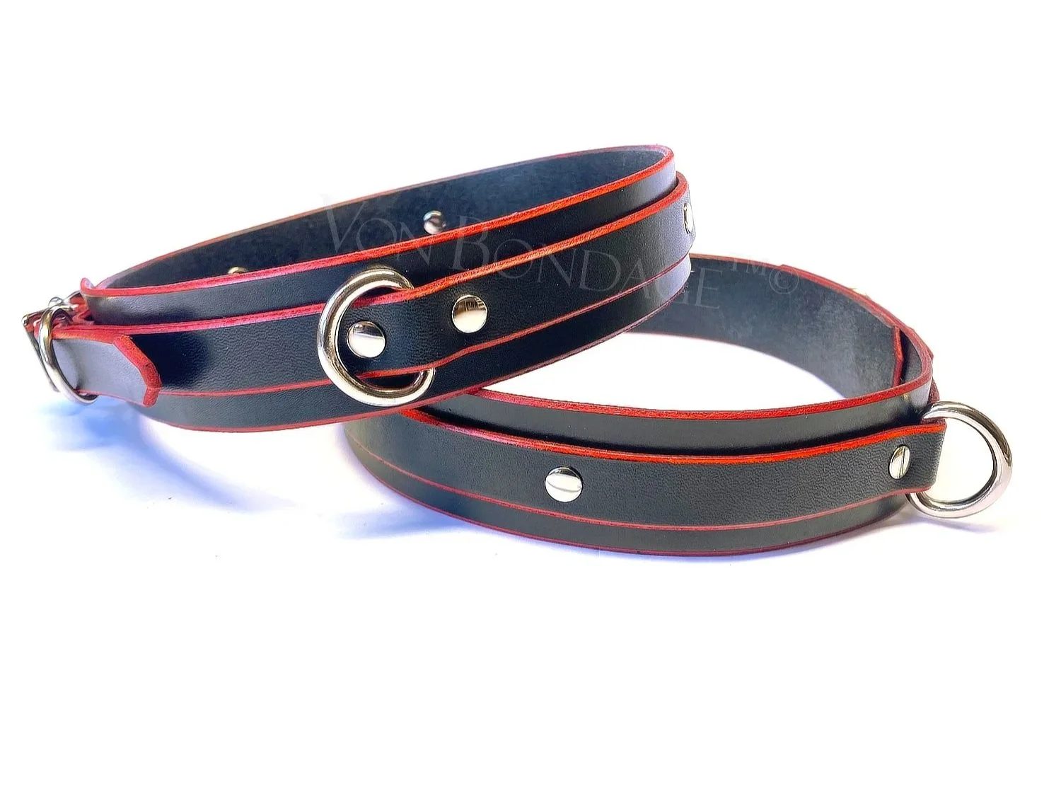 pair of leather thigh restraints with a bright red trim