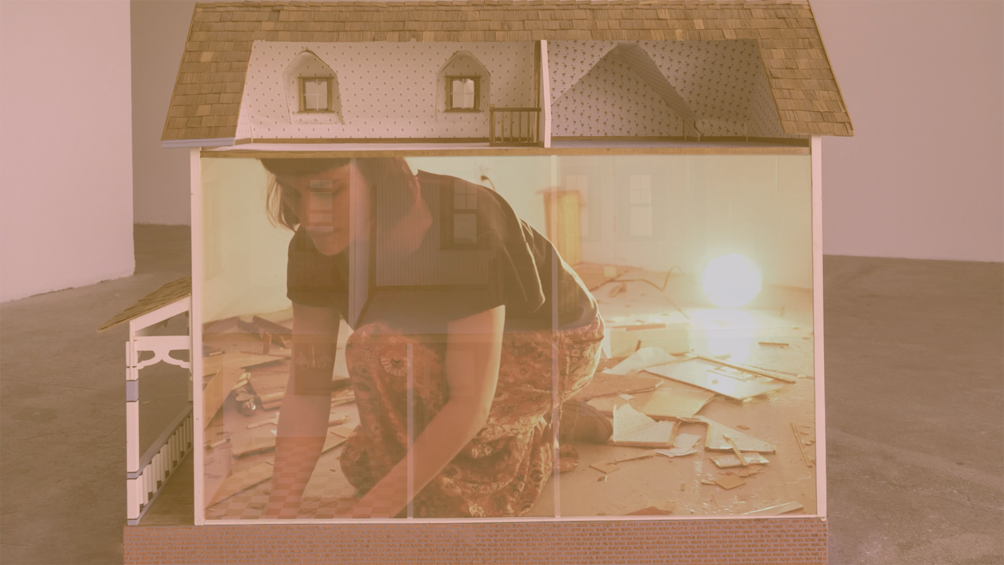 The dollhouse was built by the artist when she was 11-years-old and was a replica of her Oregon childhood home. For decades the house was forgotten amongst the accumulation of her family's belongings. After its rediscovery in early 2018, the object was the focus of various conceptual actions which culminated in its destruction - as depicted here.