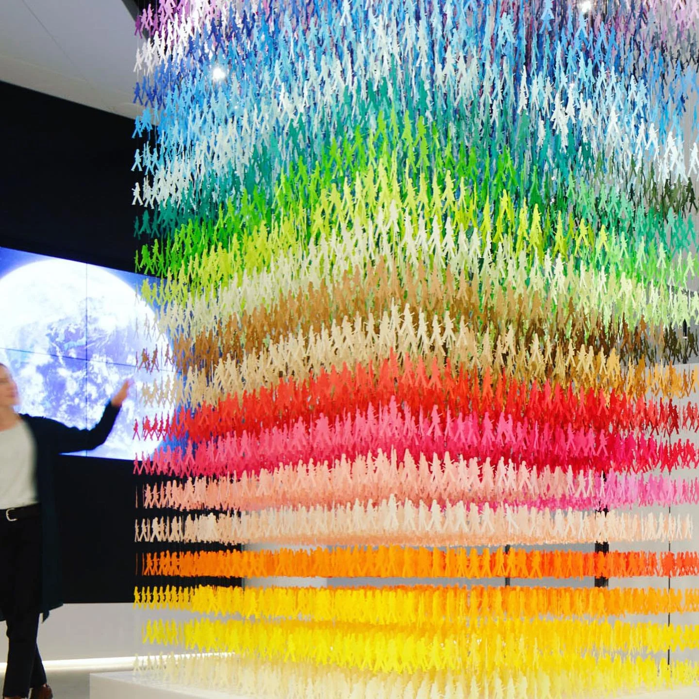 Composed of 18000 woman&rsquo;s silhouettes in 100 shades of colors, the &ldquo;100 colors&rdquo; installation &ldquo;I am here&rdquo; is an expression of non-stopping crowded street in Tokyo. Almost drowning inside the crowd, three silhouettes (two 