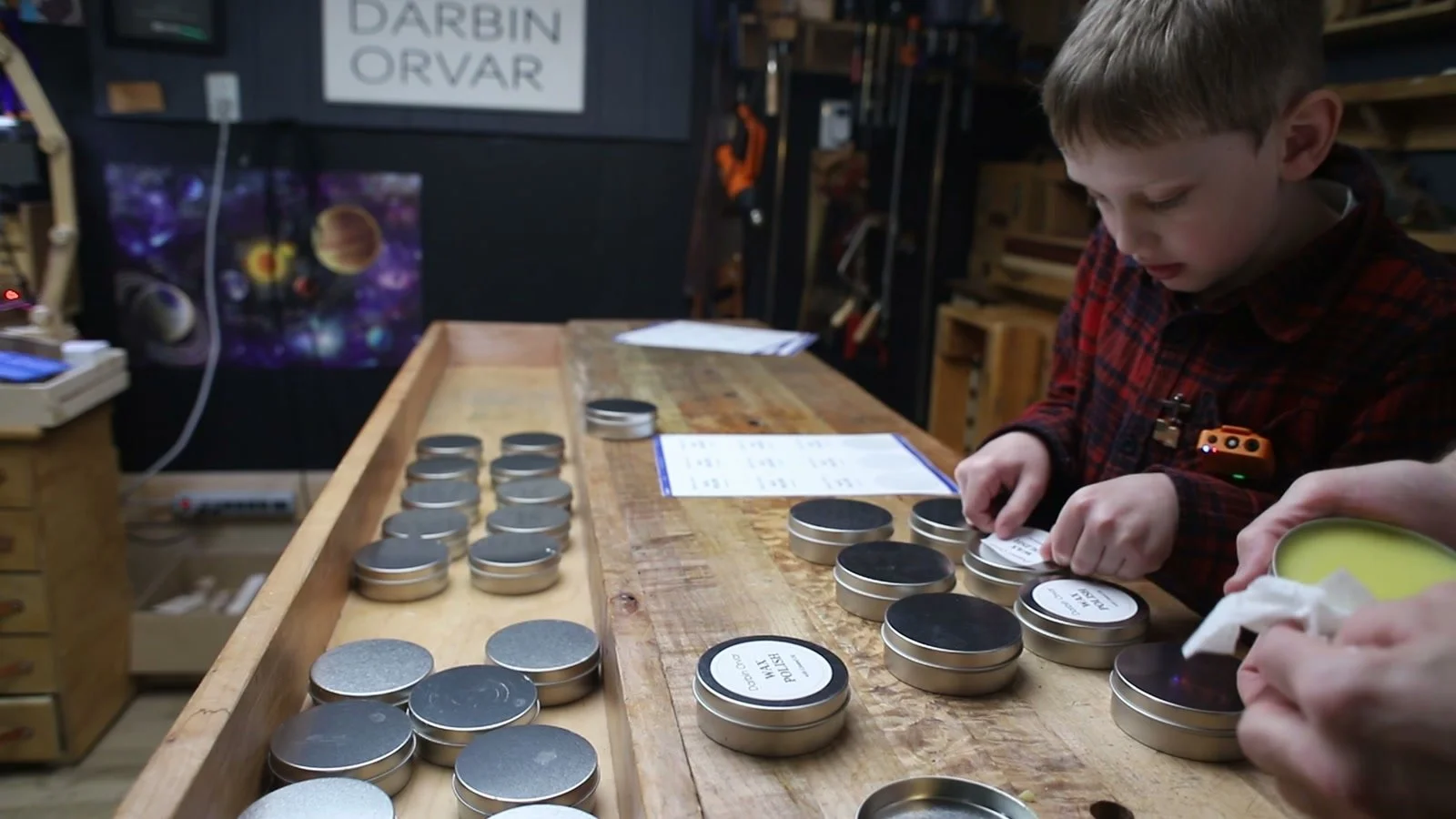 Adding labels to the cooled tins of handmade beeswax polish