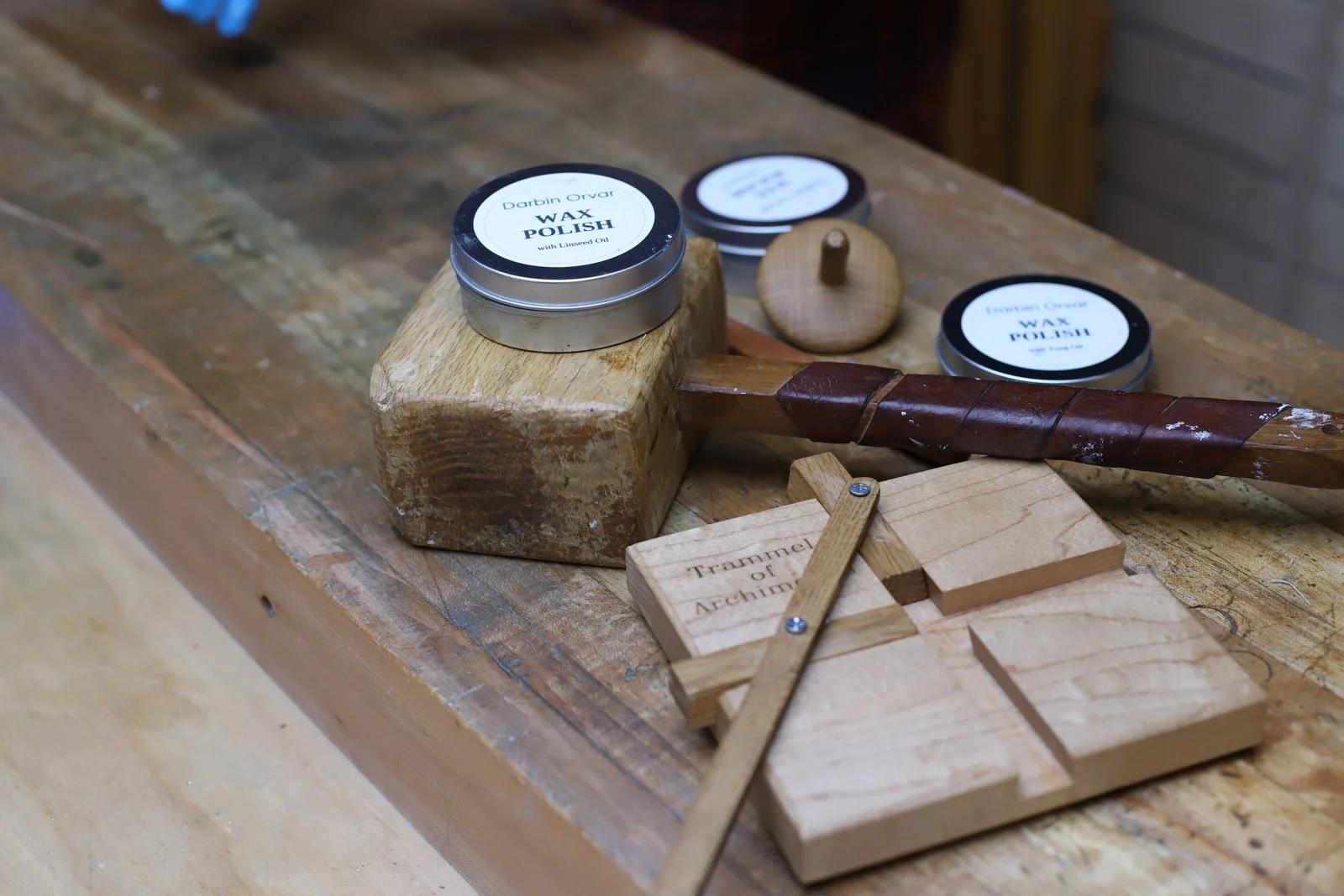 Wooden mallet, trammel, and beeswax polish tins on the workbench