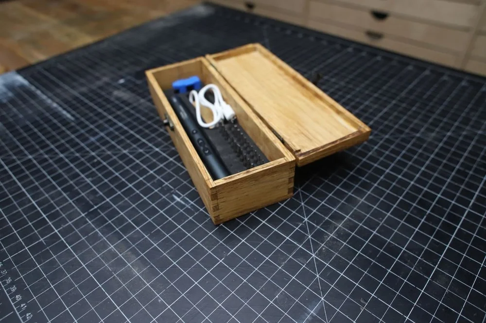 The finished box open, with the screwdriver, bits, and cable in the foam tray