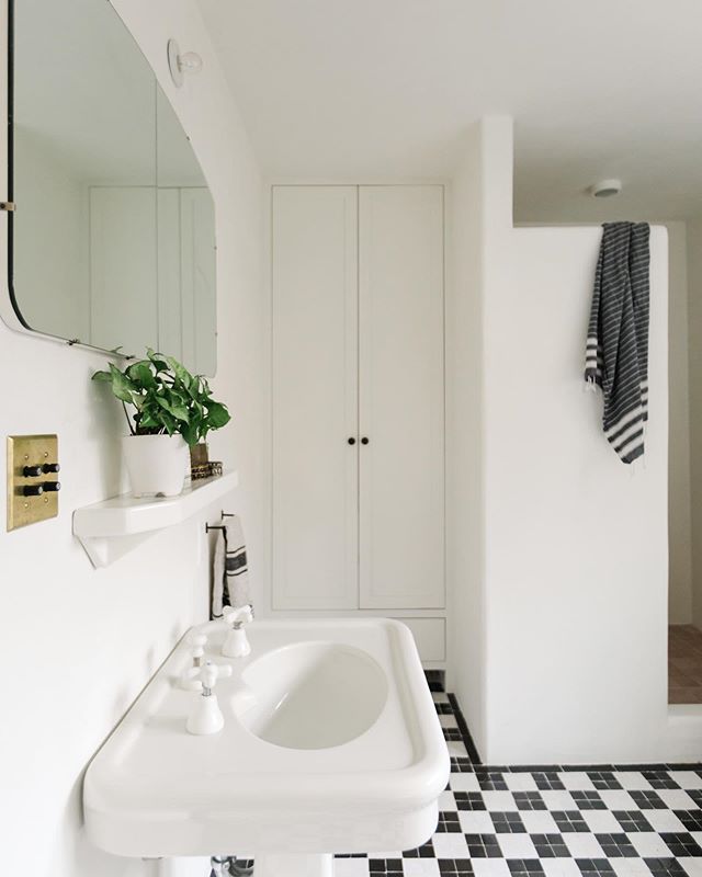 This dreamy bathroom blends 1920s charm and North African earthiness. The floor tiles were sun-dried and hand-chiseled to reimagine a classic checker patter. Plastered walls allowed us to create a wonderfully minimalist shower. A salvaged sink and a 