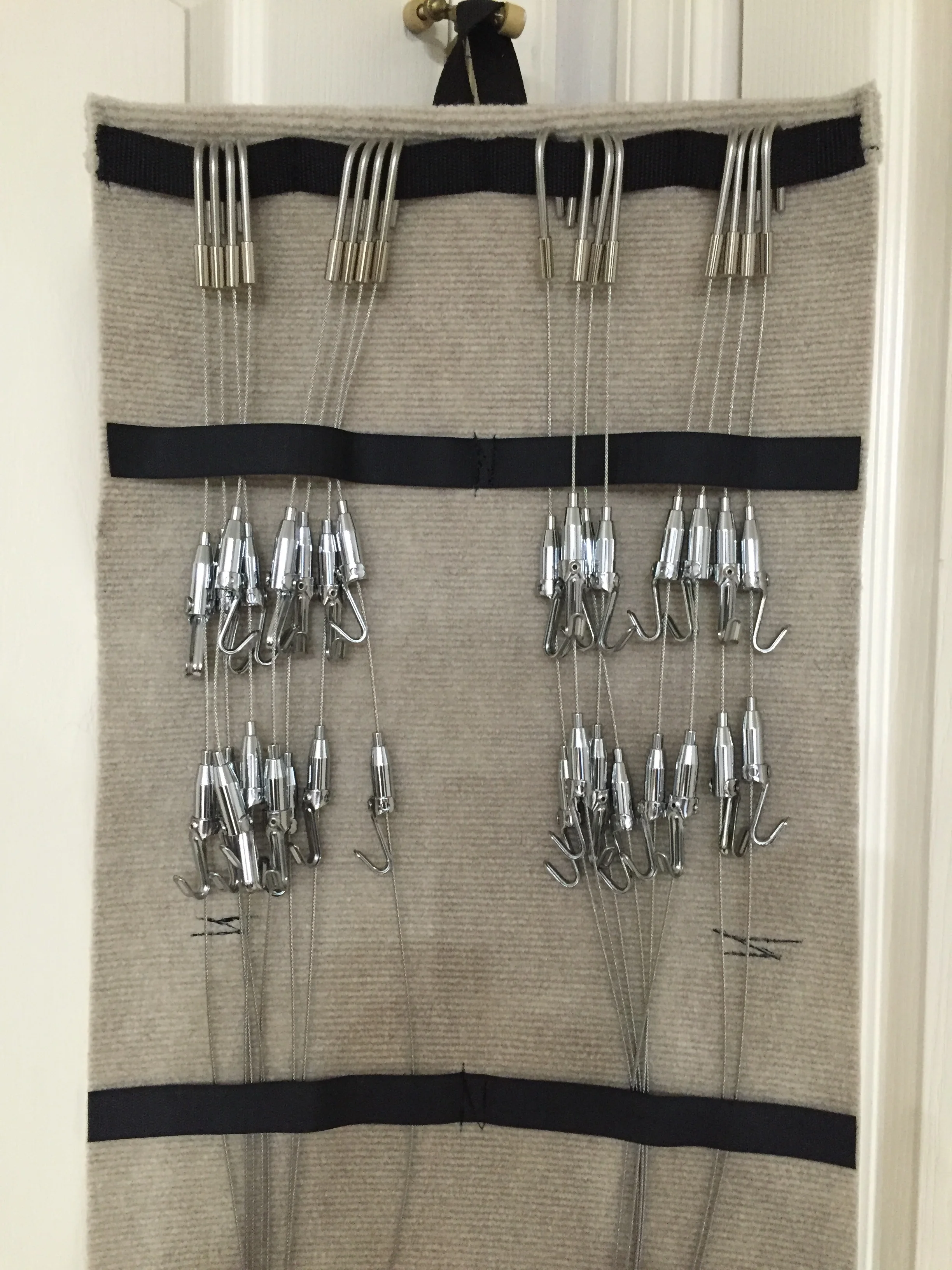 Detail of the grips (hooks) that slide up and down the cables with the push of the button on top.