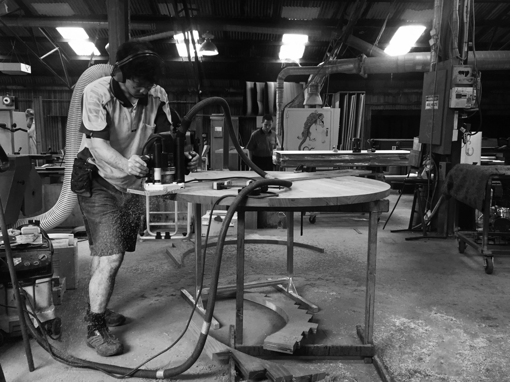 Hiroshi Yamaguchi running an edge profile into salvaged red hardwood for the dowel leg table