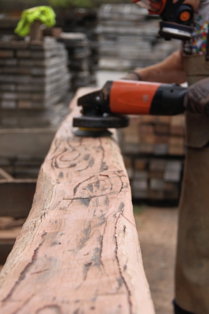 Salvaged post being wire brushed with the grinder to expose the natural character of the timber.