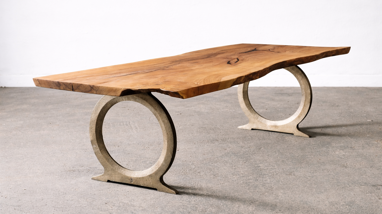 A modern bench with a thick, natural wood slab seat and two circular concrete supports.