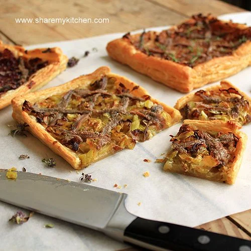 Pissaladière is best described as a focaccia/pizza base with caramelized onions, anchovy and onion. Sometimes cheese is added. It make a tasty appetizer to have with a cocktail!