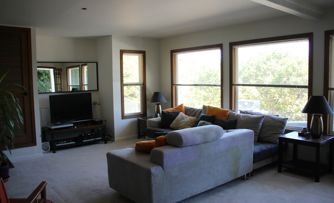 After: By removing the oversized black leather couches and shifting the grey sectional to an "L," the living room is optimized for ease of access as well as conversation. 
