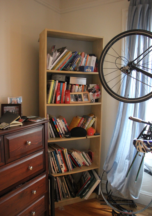 Before: The corner of the bedroom is overwhelmed by visual clutter on the dresser surface and haphazard bookshelf.