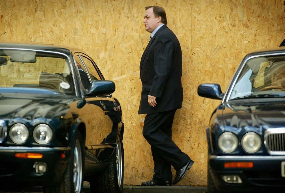 Deputy Prime Minister John Prescott walks between two Jaguar cars. London, England. October 2002.