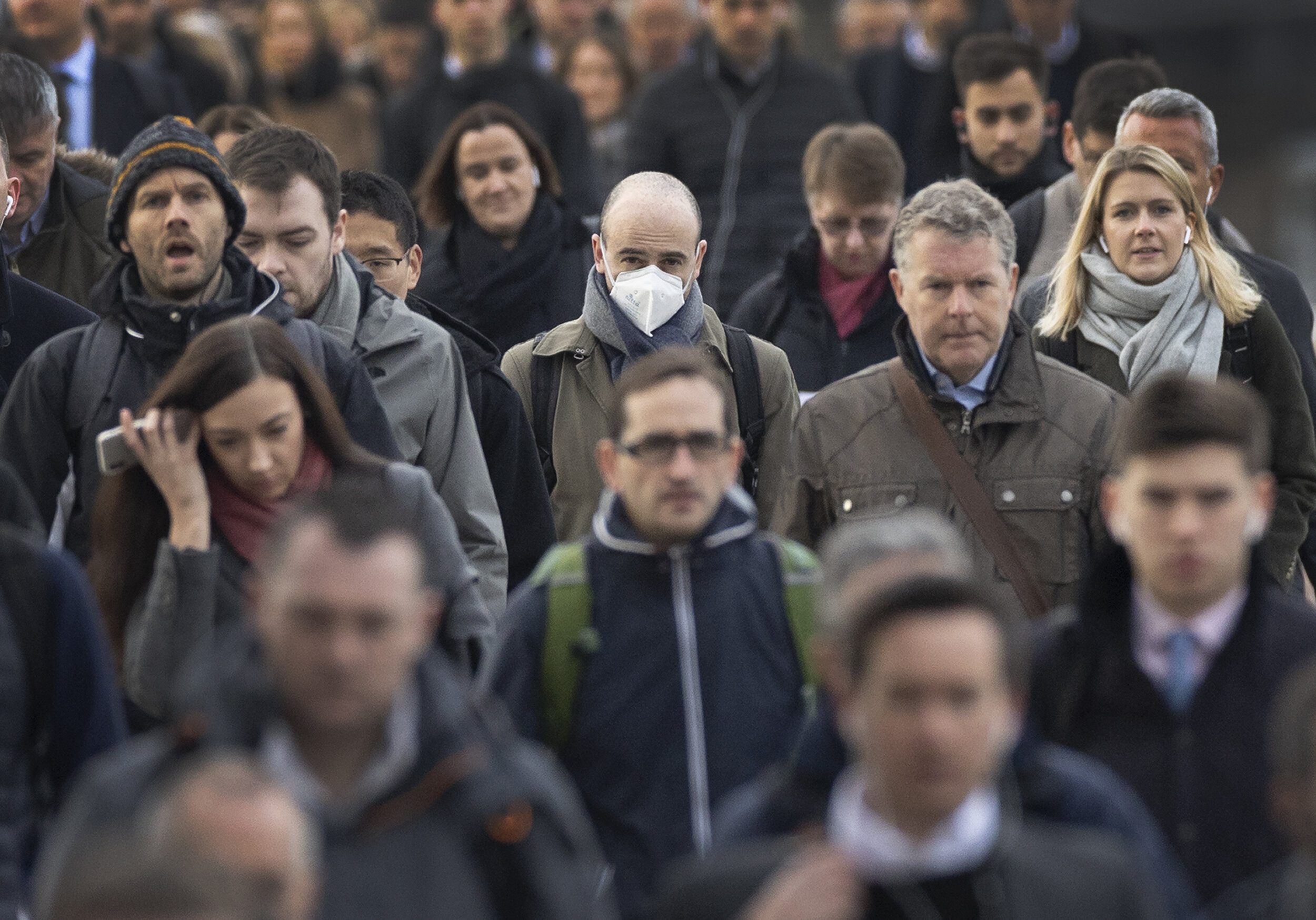 A lone commuter wears a face mask as he crosses London Bridge on March 4, 2020.