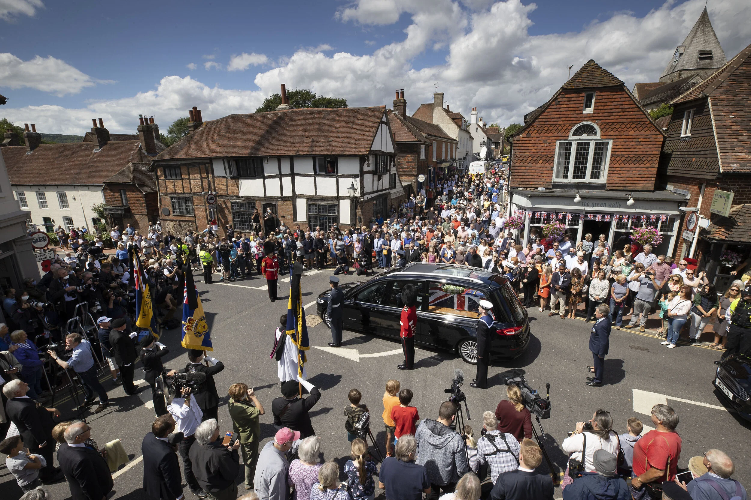 Crowds fill the High Street as the funeral cortege carrying the body of WWII Forces' Sweetheart Dame Vera Lynn passes through her home village of Ditchling, East Sussex on July 10, 2020.