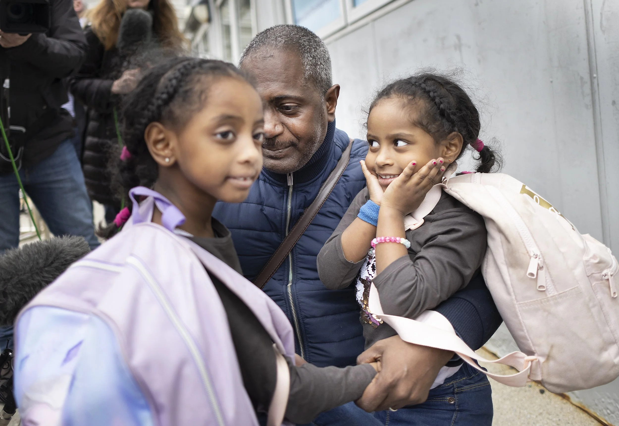 Four year old Lamar (R) looks at her father Mohamed Elamin and her sister Lujain (6) at Stansted after evacuation from war torn Sudan on April 26, 2023.