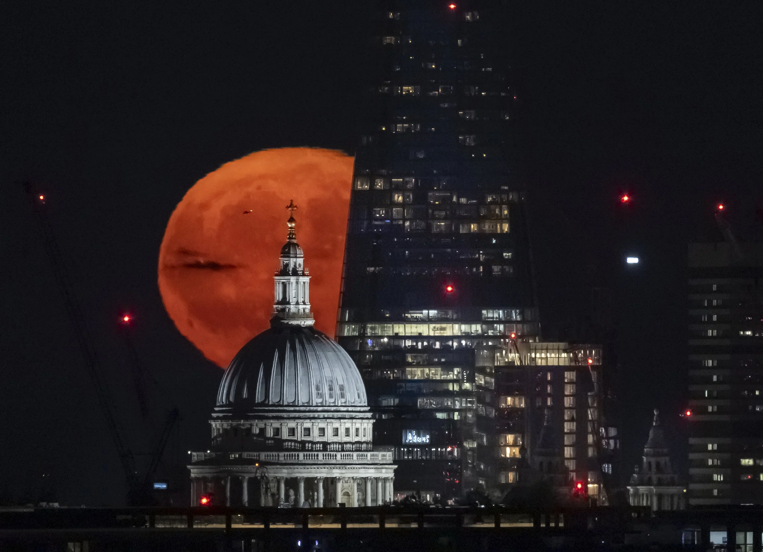 A spectacular full moon, known as the Strawberry Moon, rises over St Paul's Cathedral and The Shard in central London on June 22, 2024.