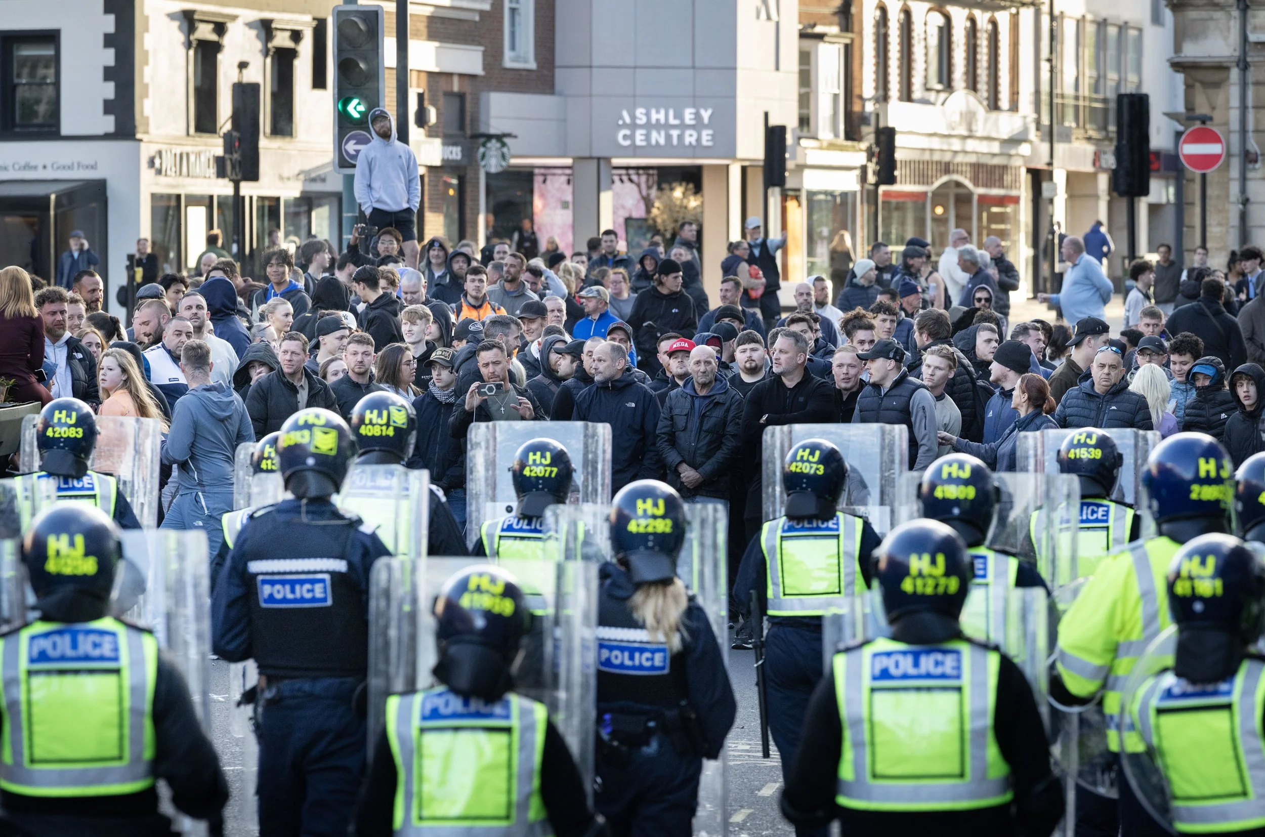 Protestors face riot police during a demonstration calling for the release of the identity of alleged rapists in Epsom, Surrey April 15, 2026.