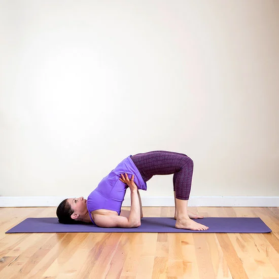Directions: Start by lying on your back with your arms to the side of your body with your palms to the floor. Bend your knees up and place your feet flat on the floor. Walk your heels as close to your butt as you can. Lift your hips up with your fit firm on the ground. Try to keep your thighs parallel. Hold this pose for five breaths. Source/Images: POPSUGAR