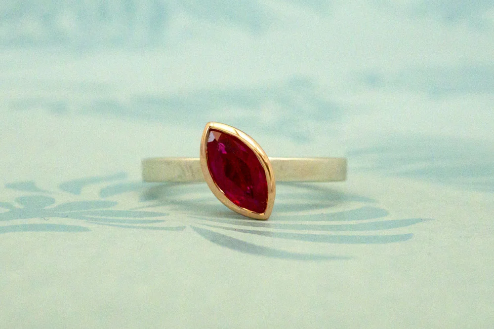 Marquise shaped ruby set in 9 carat rose gold on a silver band