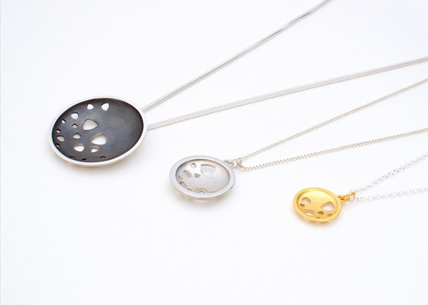 Three scattered trillions pendants in different colours and sizes. The large pendant is oxidised silver, the medium one is silver and the small one is 22 carat yellow gold plated silver. But you can have any size in any of these finishes, plus I make