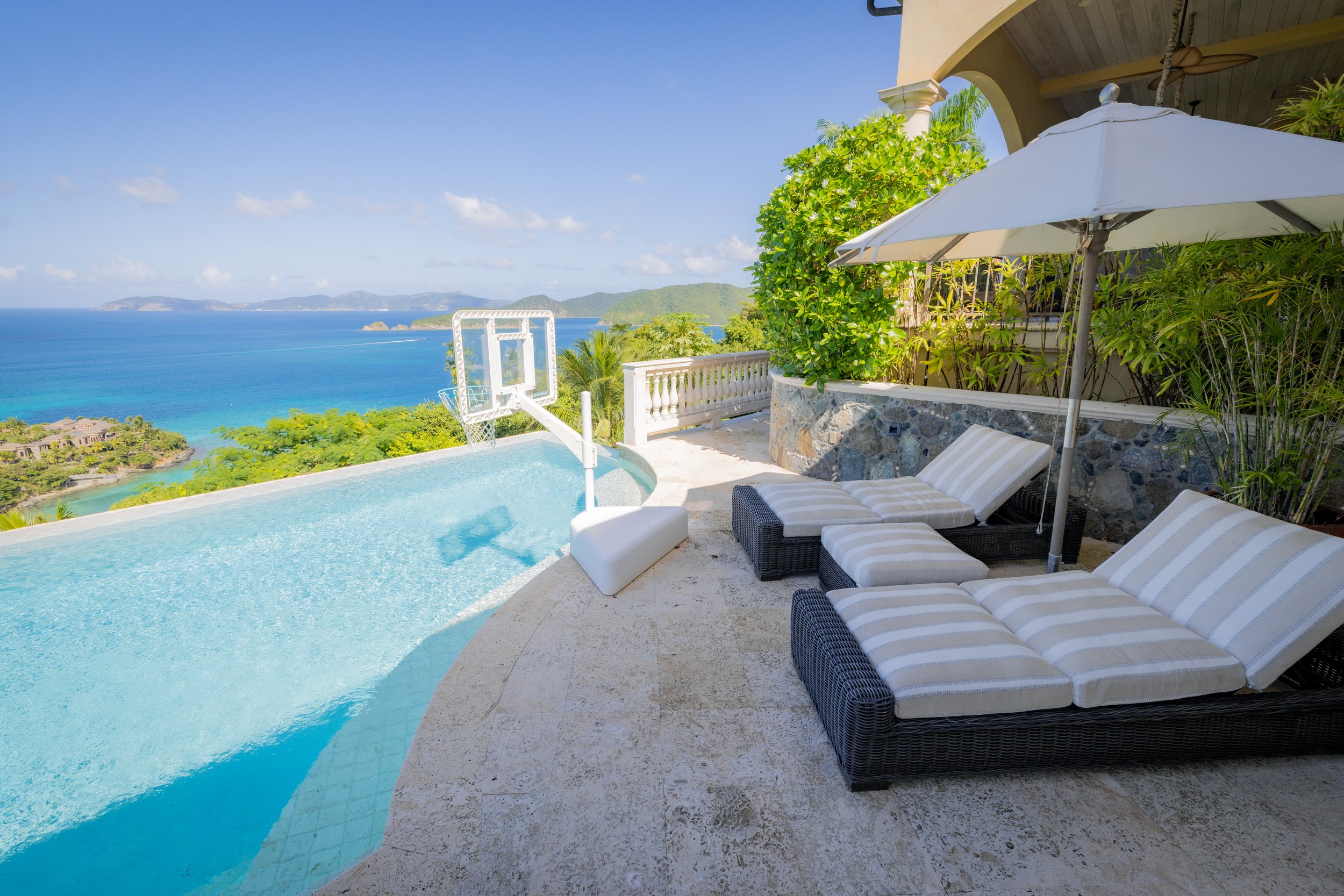 Multiple outdoor lounge chairs and a basketball net 