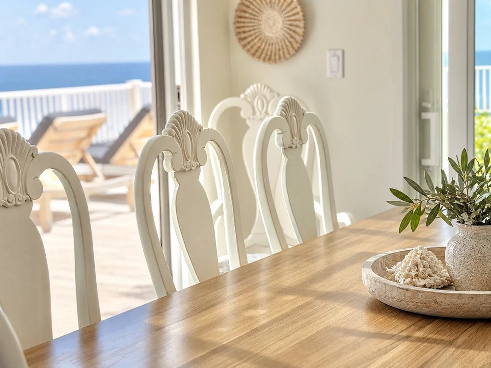 Dining chairs and tabletop styling framed by the sea