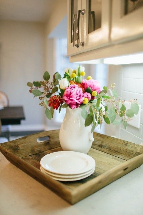 The Magnolia look: white counter tops, white cabinets, and white dishes mixed up with a raw wood tray. Photo from: Magnolia Market