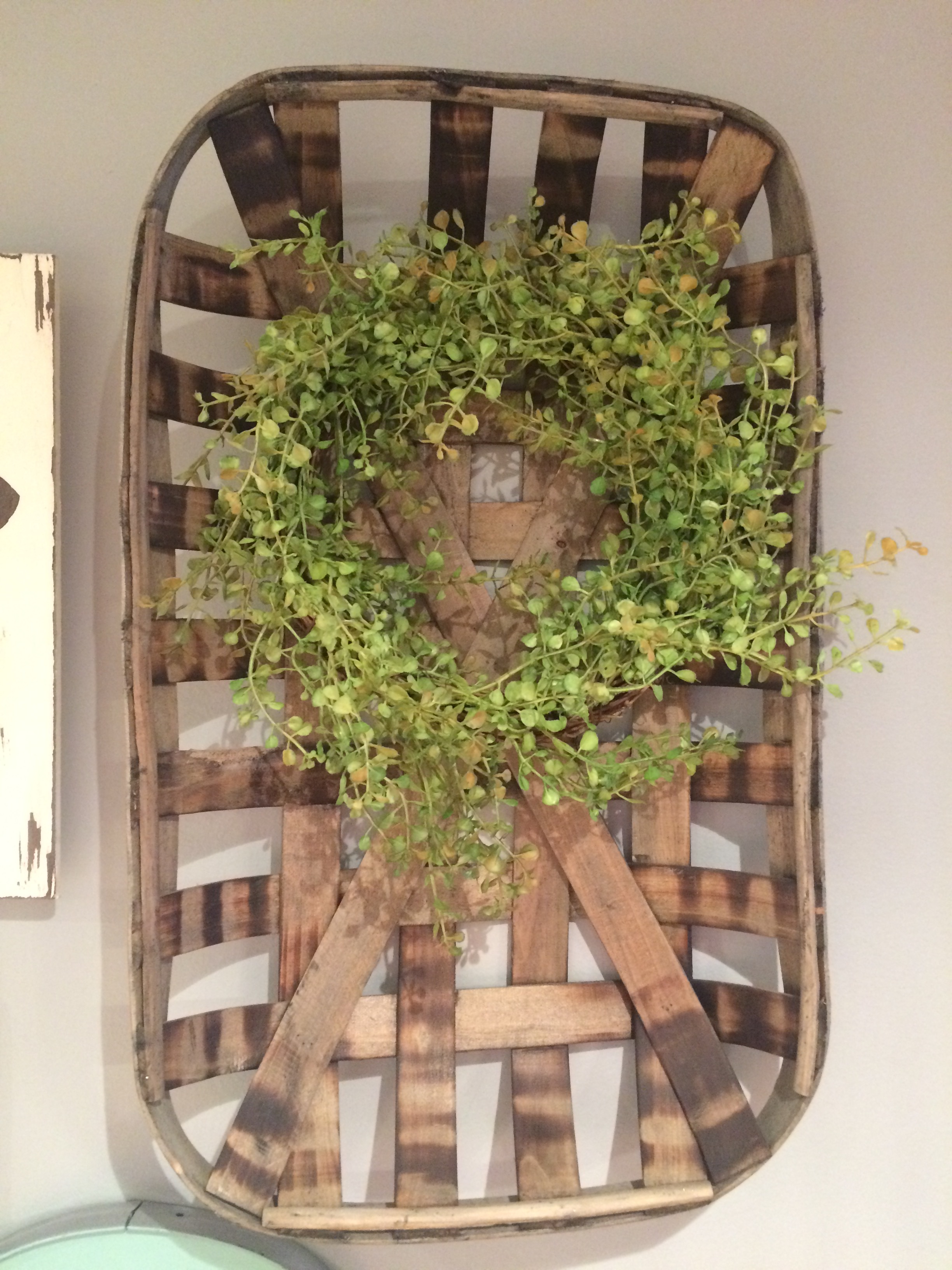 We added some color to this old basket hanging on the wall with a sweet little green wreath. Photo from: Chrysy Huff