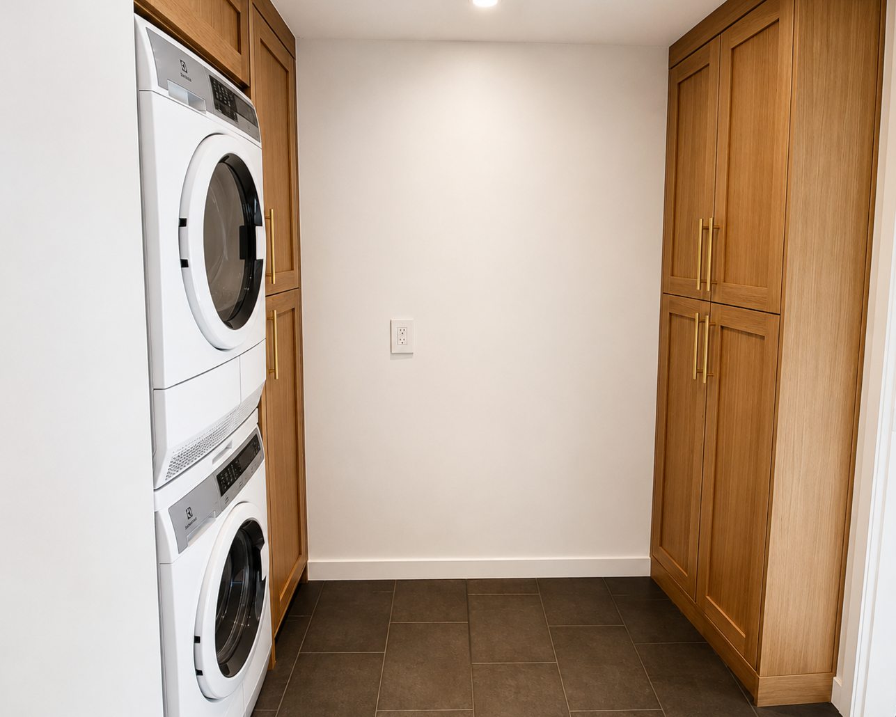 Custom laundry room renovation with stacked washer dryer and built-in cabinetry in Portland
