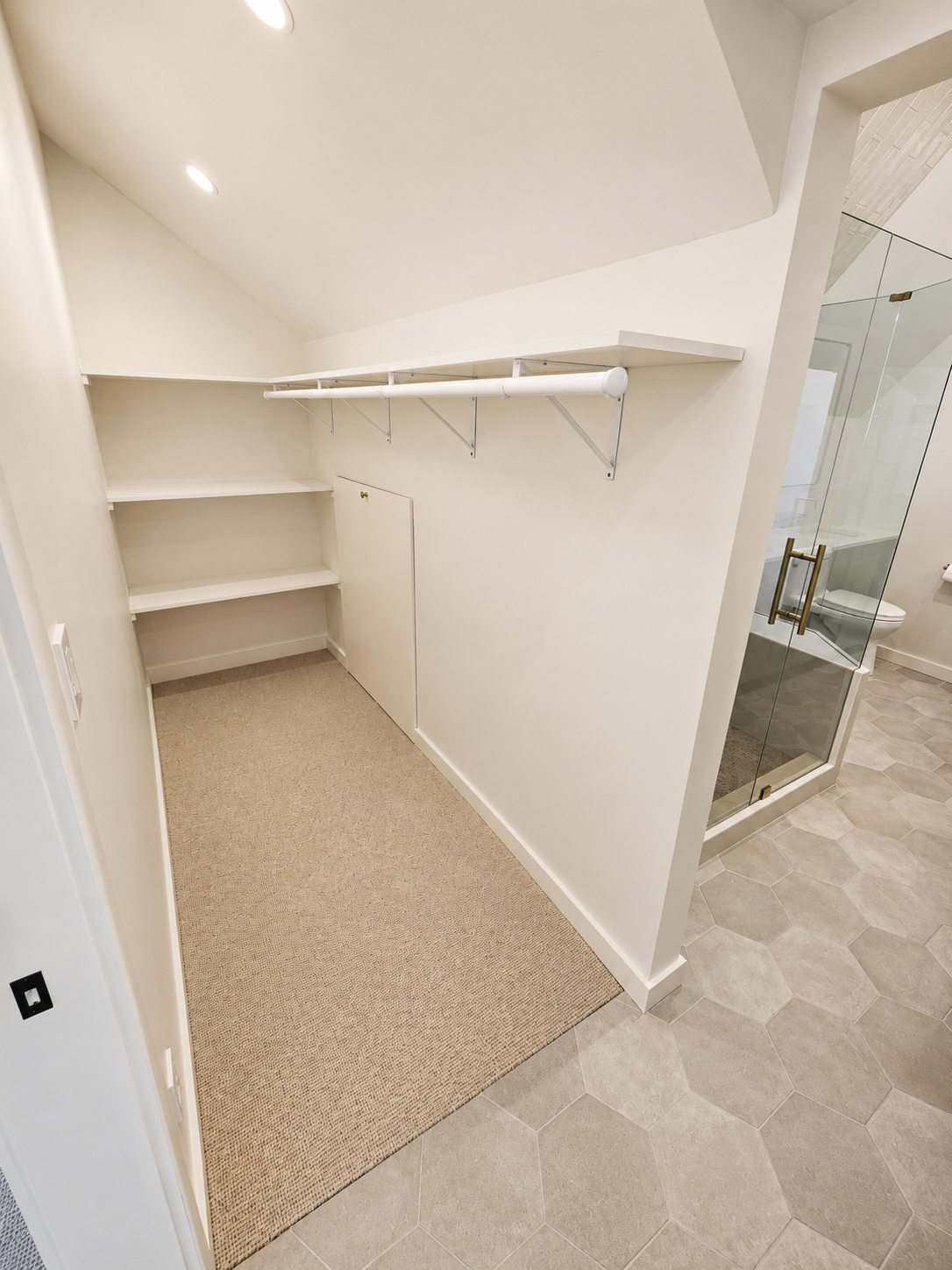 Custom walk-in closet with built-in shelving and hanging storage created during a Northeast Portland primary suite remodel.