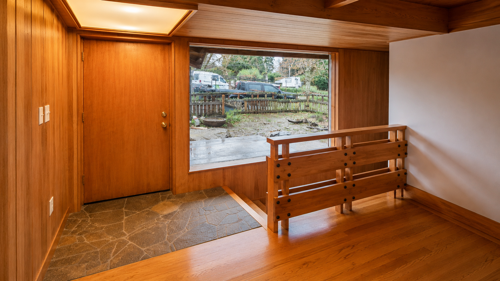Custom entry landing with architectural wood detailing in a basement ADU conversion.