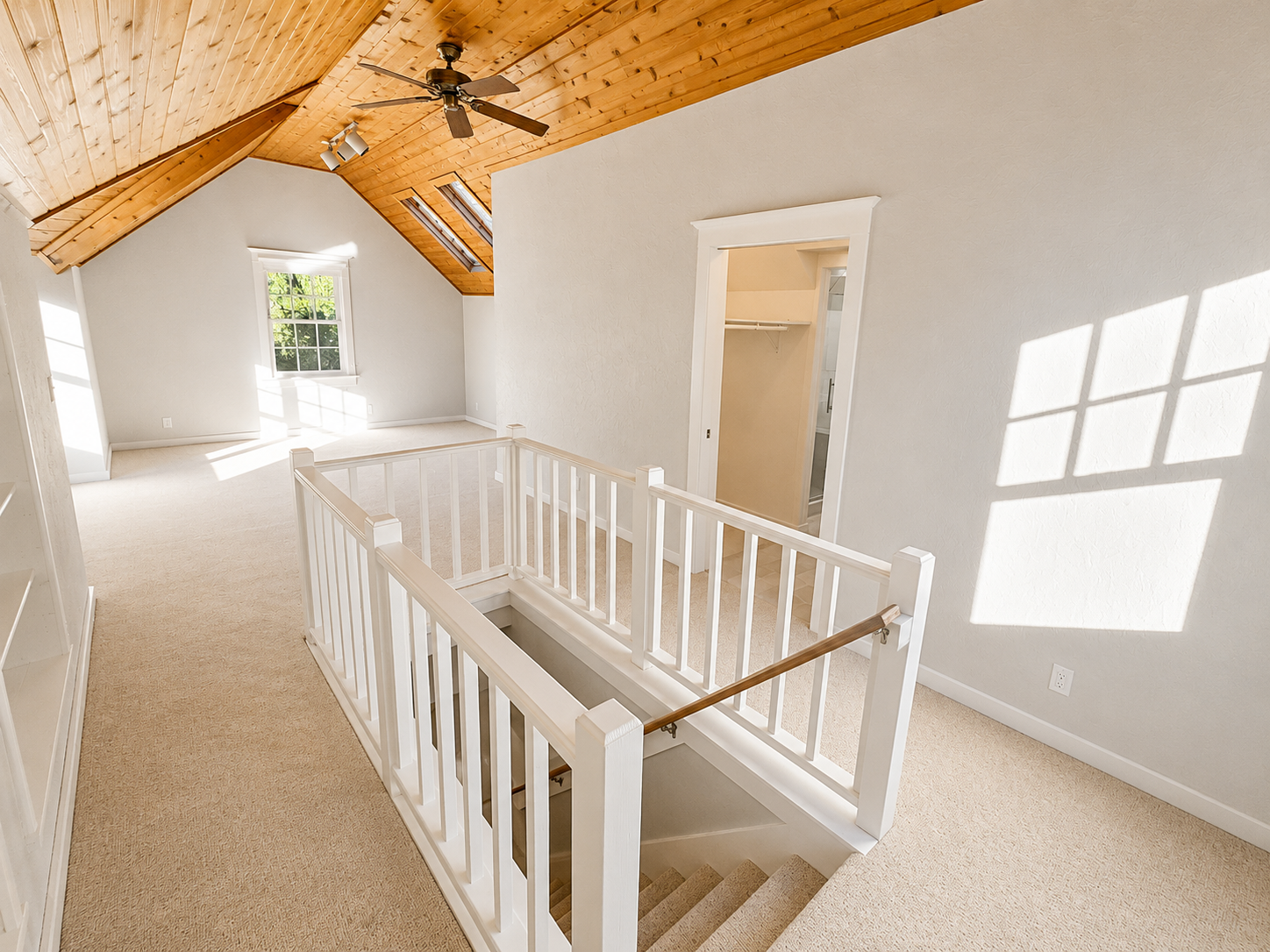 Updated primary bedroom with custom railings, vaulted ceilings, built-in storage, and new finishes as part of a whole primary suite remodel.