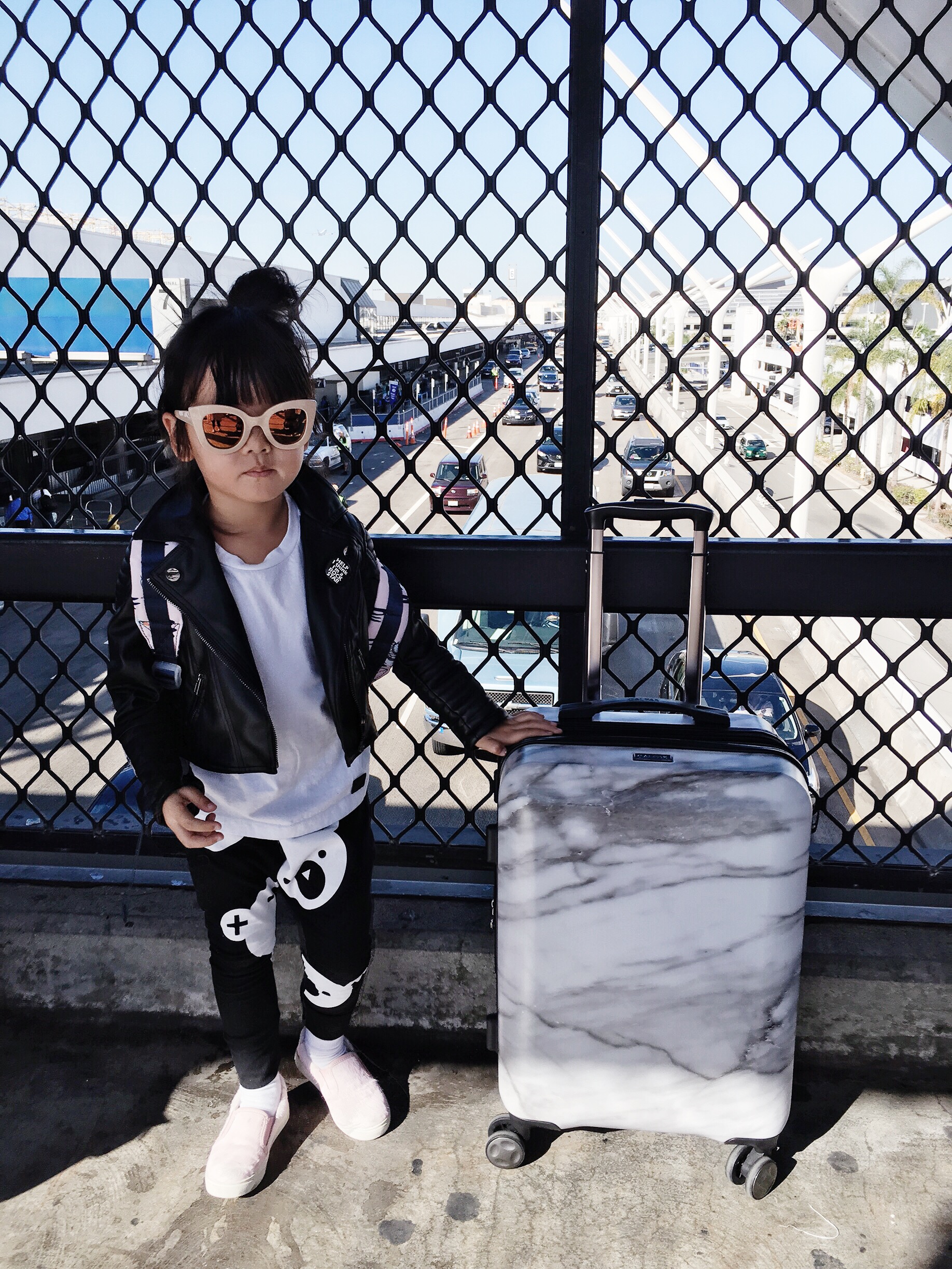 Zooey’s Airport Style: Carry on Marble case: Calpak , Sunnies: Sons + Daughters , Vegan Leather Jacket: Eve Jnr , Tee: Minixstyle , Pants: Huxbaby , Sneakers: AKID (easy to take off on the plane!)