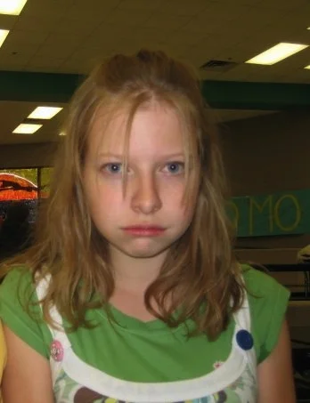 I'm not sure what this facial expression is. But I'm even more concerned about the ugly green teeshirt under an even uglier looking dress. I didn't know anything about makeup at this point in my life, and was unaware that you could color your hair, or part it on the side, or - apparently - brush it.