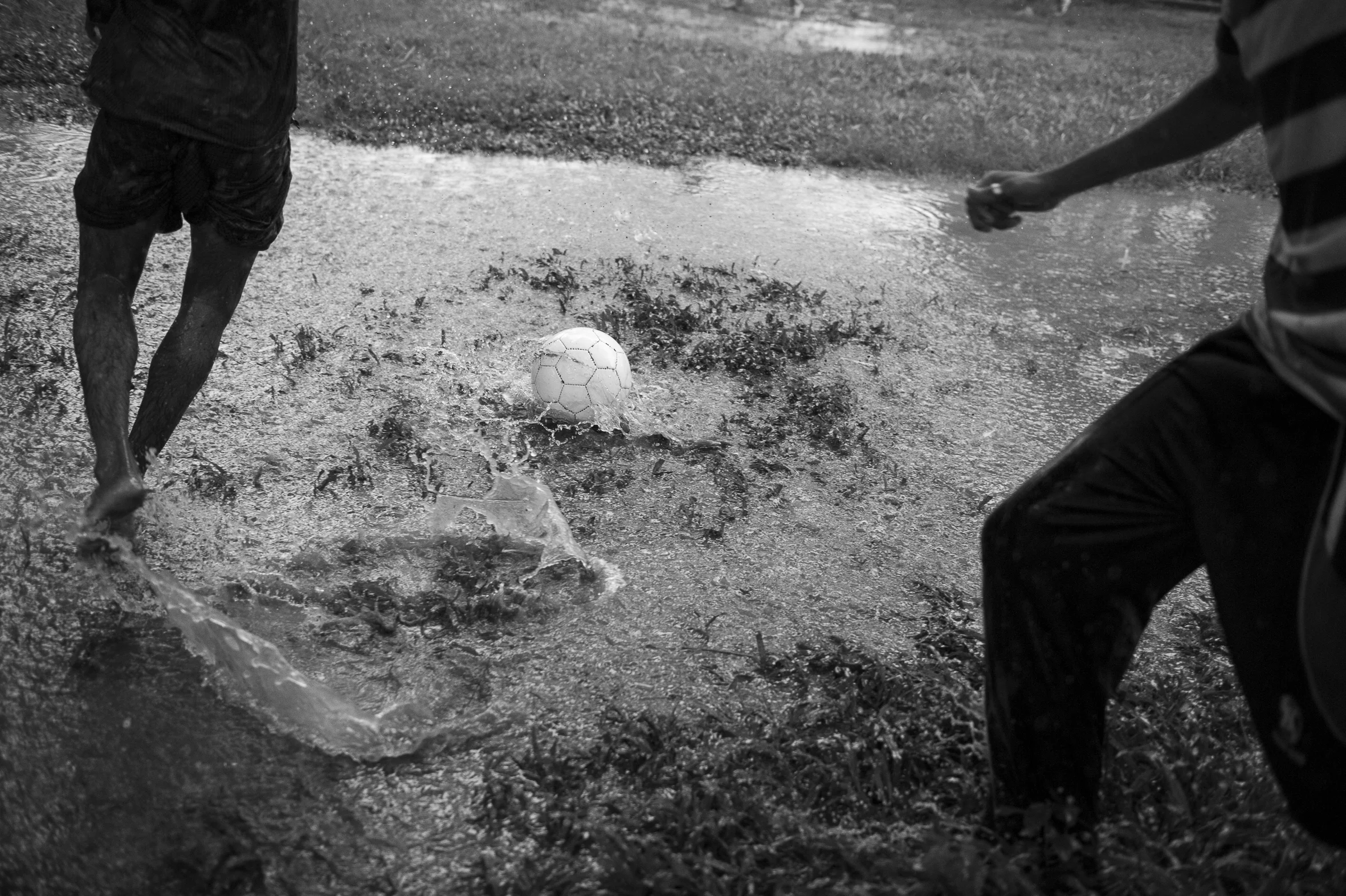 Teenager play football under the pouring rain in Ramna Park, Dhaka. June 6th, 2013.