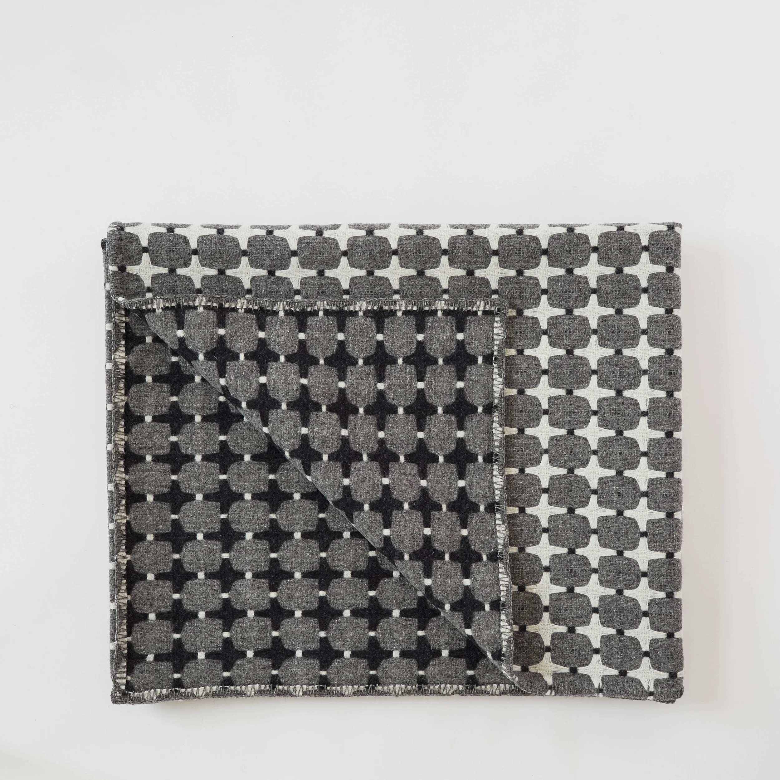 405 Line Blanket A statement piece, not an over statement. The monochrome palette is reversible, woven in 100% wool in Wales. £320