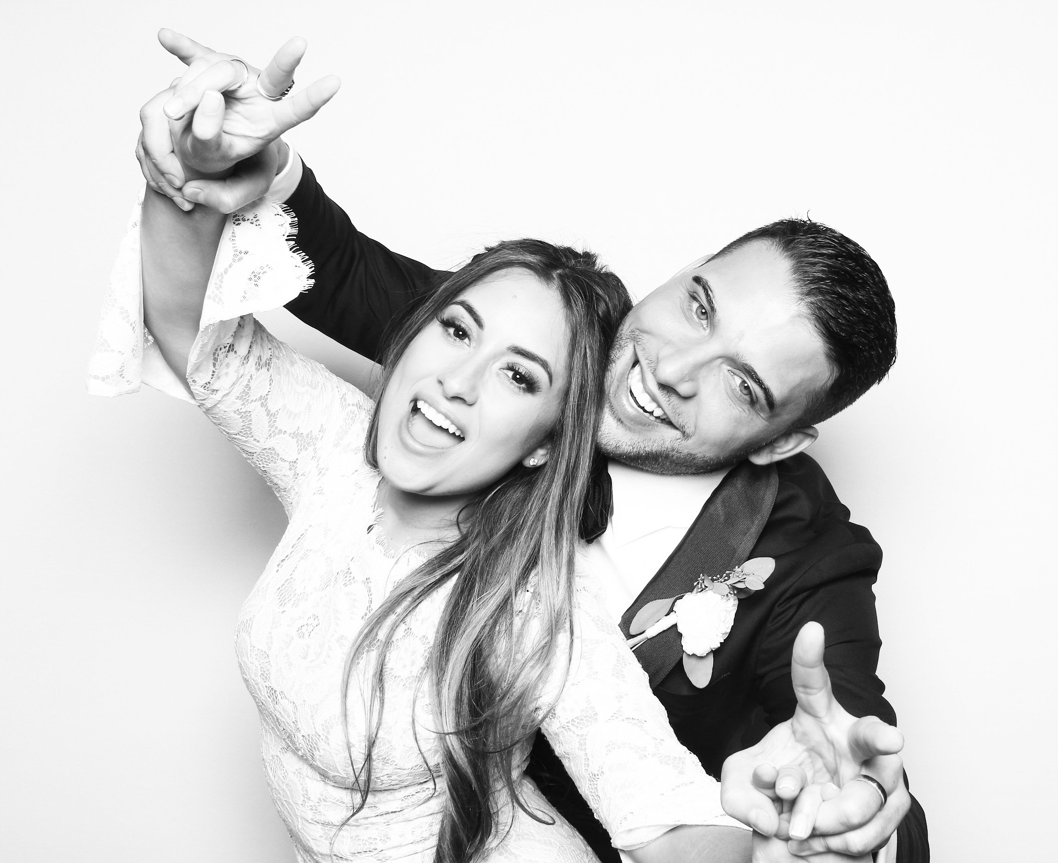  A bride and groom posing for a black and white photobooth picture. 