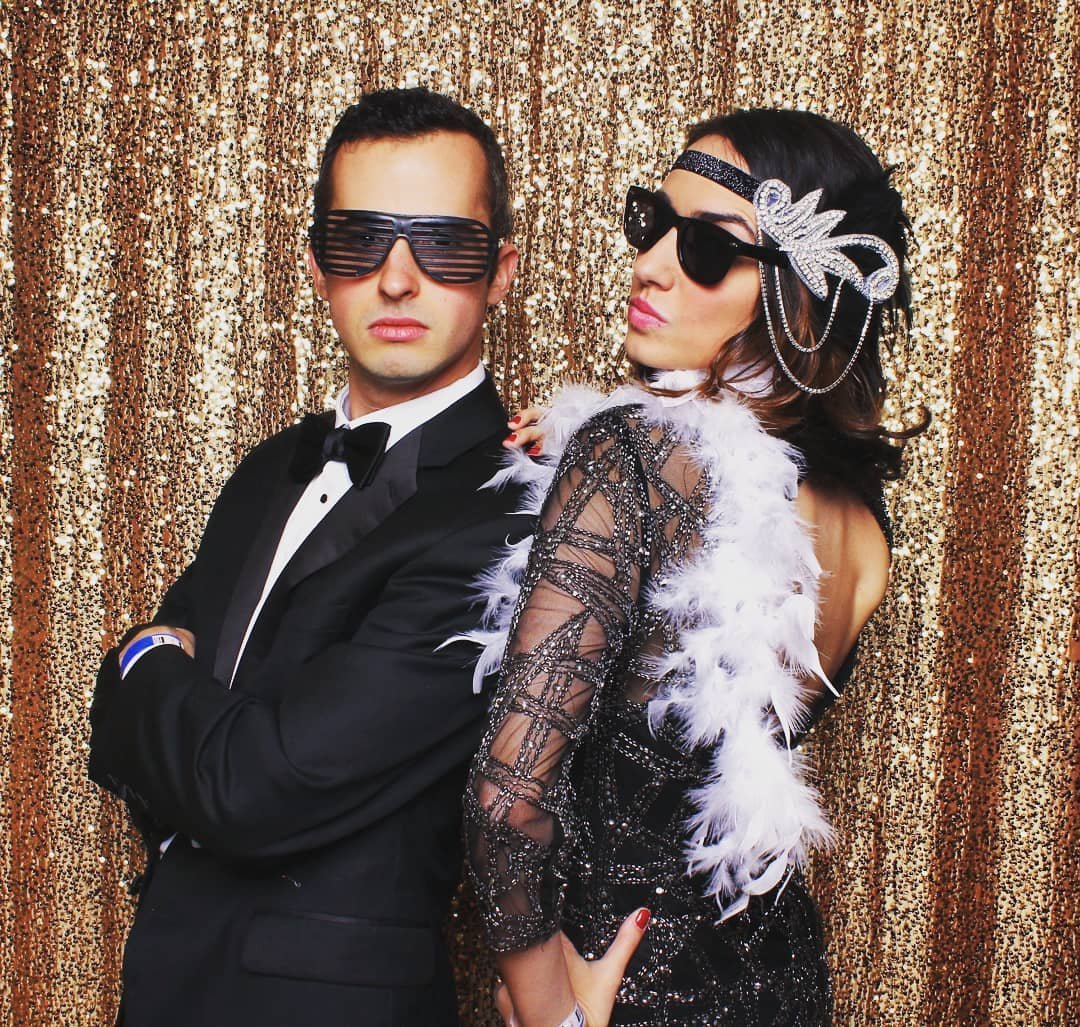  A woman and man with sunglasses striking a tough pose for a picture. 