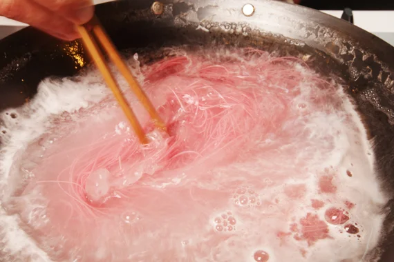 3. 梅子細麵煮約1-2分鐘後,用冰水冰鎮瀝乾取出,再將麵條與冰塊一起放入竹簾盤中。