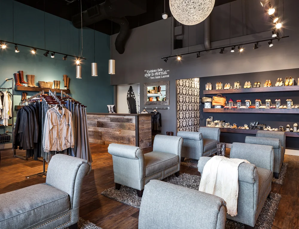 Boutique shop interior with a dark ceiling, woven pendants and clothing racks