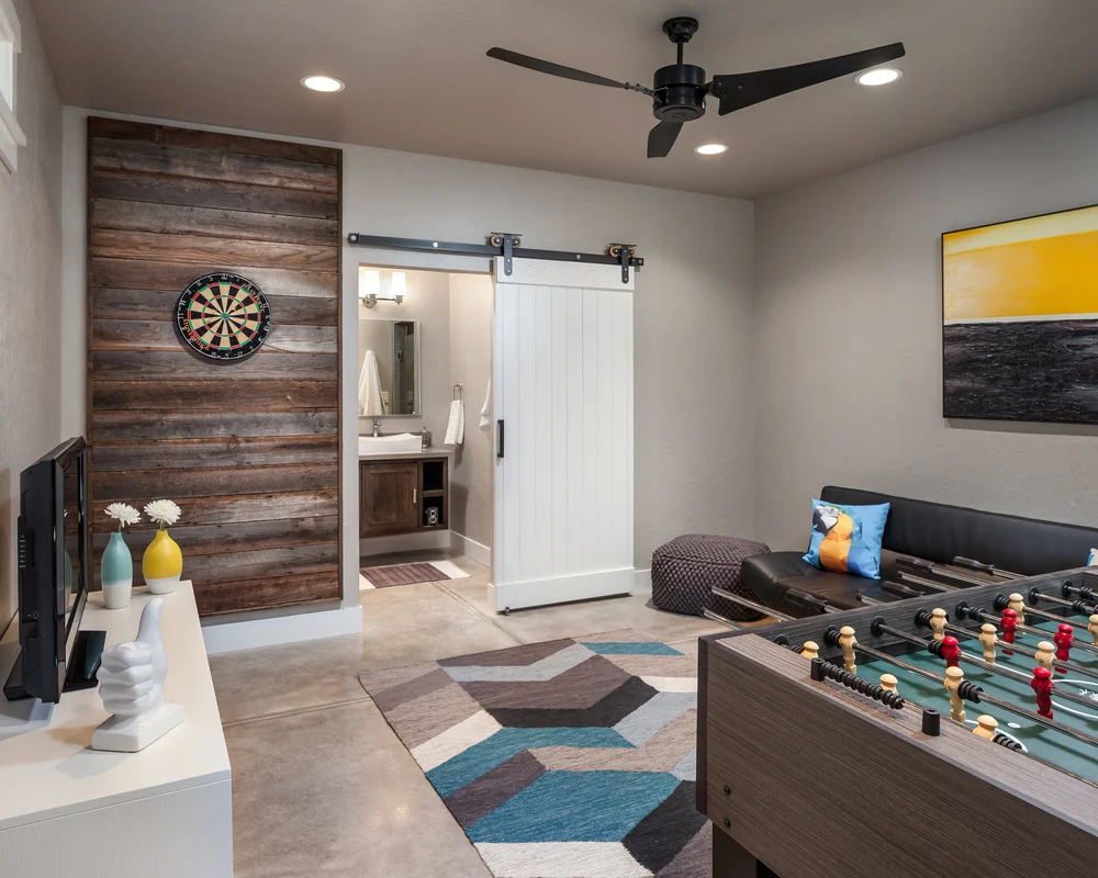 Pool house lounge with a reclaimed wood wall, dartboard and barn door